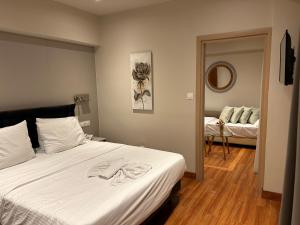 a bedroom with a large white bed with a mirror at Anemoni Piraeus Hotel in Piraeus
