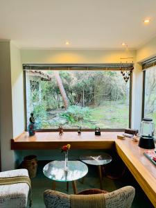 Habitación con ventana con mesa y sillas en KURALEMU Casa de Campo, en Curacaví