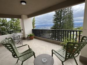 a balcony with two chairs and a table with a view at Camp David Ranch in Santiago de los Caballeros