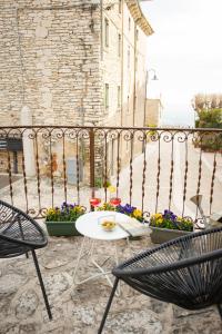eine Terrasse mit 2 Stühlen, einem Tisch und Blumen in der Unterkunft Residenza Borgo Valpolicella in SantʼAmbrogio di Valpolicella