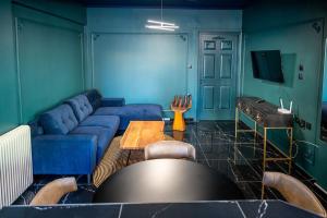 uma sala de estar com um sofá azul e uma mesa em Apartments center em Lárissa