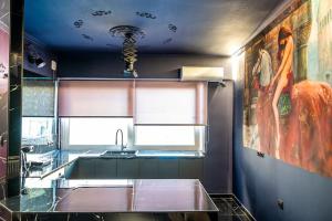 uma cozinha com um lavatório e uma pintura na parede em Apartments center em Lárissa
