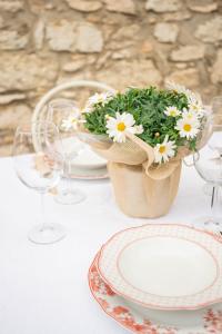 einen Tisch mit Platten und eine Kanne Blumen in der Unterkunft Residenza Borgo Valpolicella in SantʼAmbrogio di Valpolicella