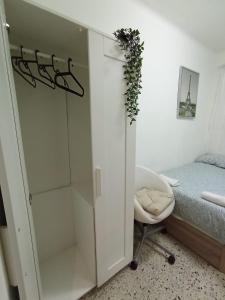 巴塞隆納的住宿－Room Familiar nube paraiso，卧室内的白色橱柜,配有床和椅子