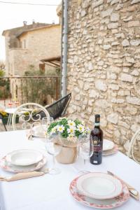 einen Tisch mit Tellern und Gläsern sowie eine Flasche Wein in der Unterkunft Residenza Borgo Valpolicella in SantʼAmbrogio di Valpolicella