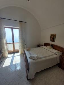 阿马尔菲Casa Orizzonte的一间卧室，里面有一张床和一扇大窗户。