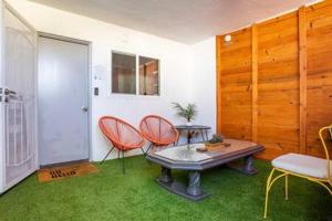een kamer met 2 stoelen en een tafel in een kamer met gras bij Mid Century 1BR Apt w Patio Near LAX Playa Vista Beach in Los Angeles