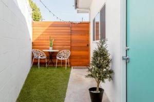 a patio with a table and chairs and a fence at Vibe on the Patio at a Modern Luxury Studio near LAX Beach in Los Angeles