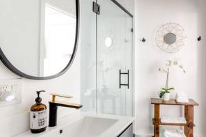 uma casa de banho com uma grande banheira branca e um espelho. em Vibe on the Patio at a Modern Luxury Studio near LAX Beach em Los Angeles