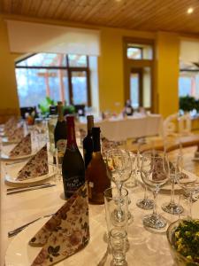 una mesa con copas y botellas de vino y pizza en Dzintara Pirts, en Vilgāle