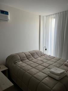 een groot bed in een kamer met een raam bij Departamentos y monoambientes Santiago 115 in Neuquén