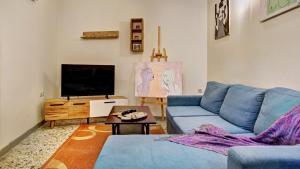 a living room with a blue couch and a tv at Sofi-Art House in Kynopiástai
