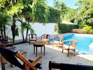 a group of chairs and a table next to a pool at Hotel Casa del Sol in Managua