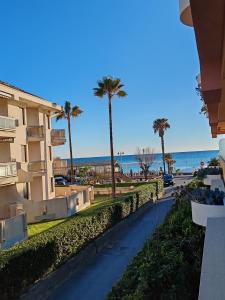 a street with palm trees and the ocean in the background at Relax al Mare in Vallecrosia