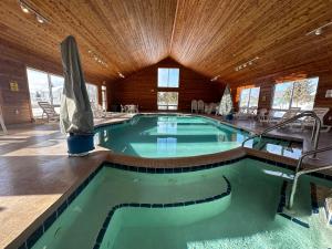 a large swimming pool in a building with a wooden ceiling at Birchwood Lodge in Sister Bay
