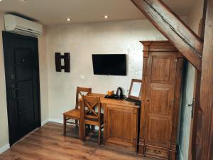 a home office with a desk and a television on the wall at Bocianówka z sauną i fotelem masującym w cenie in Ustroń