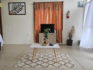 een woonkamer met een salontafel en een televisie bij Cozy Flat in San Ignacio Close to Downtown! in San Ignacio