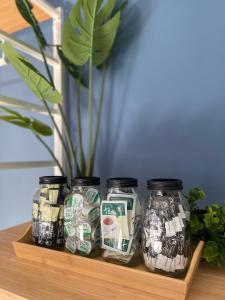 three jars of money sitting on a shelf with a plant at Pershore Rooms at The Star in Pershore