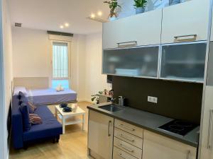 a small kitchen with a bed and a sink at Nuevo estudio junto al Guadalquivir in Seville