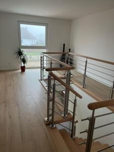 an empty room with a staircase and a window at La Perle du petit Rupembert in Wimille
