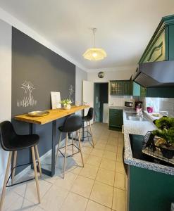 a kitchen with green cabinets and a wooden table at FeWo Jack's World in Luckenwalde
