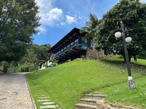 un edificio su una collina erbosa con un lampione di Casa Holanda a Teresópolis
