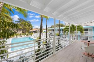 einen Balkon mit Blick auf den Pool und die Palmen in der Unterkunft The New Yorker Miami Hotel in Miami