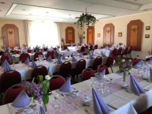 a room filled with tables and chairs with vases at Hotel Herbstein in Herbstein