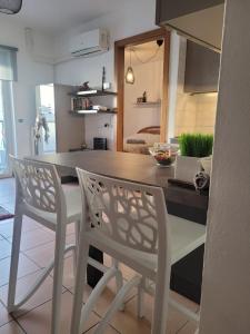 una cucina con 2 sedie bianche e un'isola cucina di Flat lemon a Trento