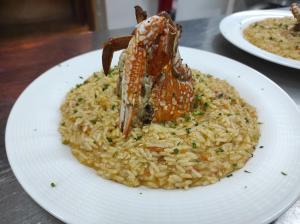 un plato de arroz con un cangrejo encima. en Hotel La Fattoria Sul Mare, en Capo Vaticano