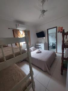 a bedroom with a bunk bed and a mirror at Pousada Nascimentos in Bertioga