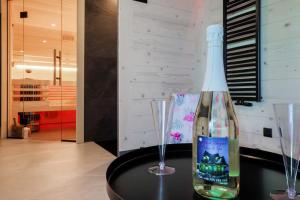 een fles wijn zittend op een tafel met twee glazen bij Domek Zakopane Deluxe & Spa na wyłączność in Zakopane