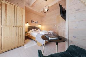 een slaapkamer met een bed en een tafel in een kamer bij Domek Zakopane Deluxe & Spa na wyłączność in Zakopane