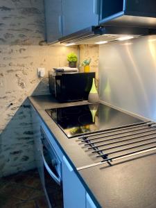 una cocina con estufa y encimera en maison cocooning, en Gesnes-le-Gandelin