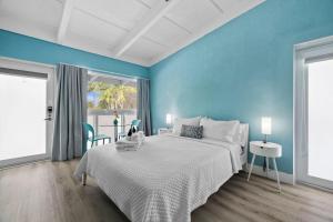 a bedroom with a large bed and blue walls at The New Yorker Miami Hotel in Miami