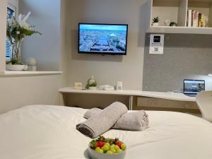 a bedroom with a bed with a bowl of fruit on it at HNFC Stays - Central Business Studio w/ gym in Newcastle upon Tyne