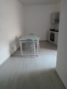 een witte tafel en een stoel in de keuken bij Dimora del Malconsiglio in Miglionico