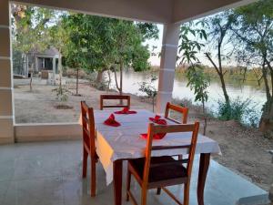 a dining room table with a view of a river at Riverside Lodge Bansang in Bansang