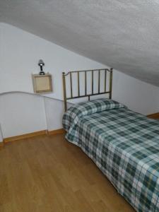 een kleine slaapkamer met een bed op zolder bij Dimora del Malconsiglio in Miglionico