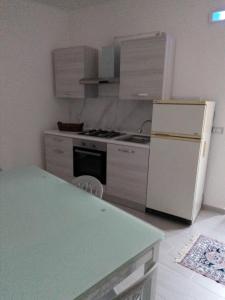 een keuken met een witte koelkast en een fornuis bij Dimora del Malconsiglio in Miglionico
