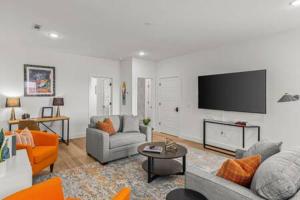 a living room with couches and a flat screen tv at The O'Keeffe-2nd Floor Boutique Hotel Suite in Bentonville