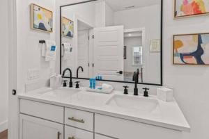 a bathroom with a sink and a large mirror at The O'Keeffe-2nd Floor Boutique Hotel Suite in Bentonville