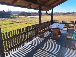 a wooden table and chairs under a pavilion with a field at Apartman T&N in Šušnjari +2 photos