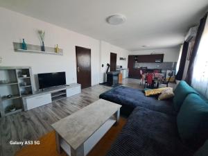 a living room with a blue couch and a table at Apartman T&N in Šušnjari