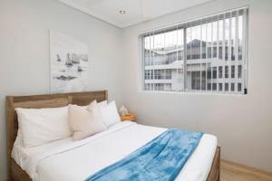 a bedroom with a large bed with a window at Oceans at Terrigal a Beachfront Oasis in Terrigal