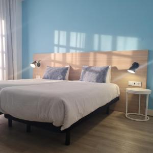 1 dormitorio con 1 cama grande y cabecero de madera en Flag Hotel Santarém, en Pernes