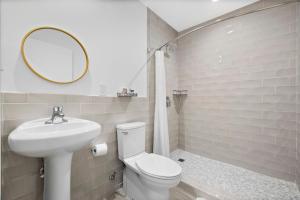 a bathroom with a toilet and a sink and a mirror at The New Yorker Miami Hotel in Miami
