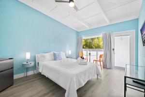 a blue bedroom with a bed and a table at The New Yorker Miami Hotel in Miami
