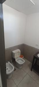 a bathroom with a toilet and a sink at Home Alojamientos Temporales in San Luis