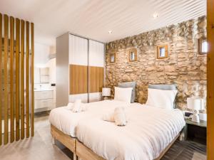a bedroom with a large bed and a stone wall at Majordoms - Mas Maria Carmen Dalmau in Sant Andreu del Terri +64 photos